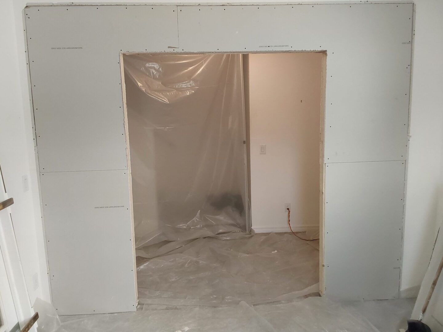 A room with walls and doors covered in plastic.
