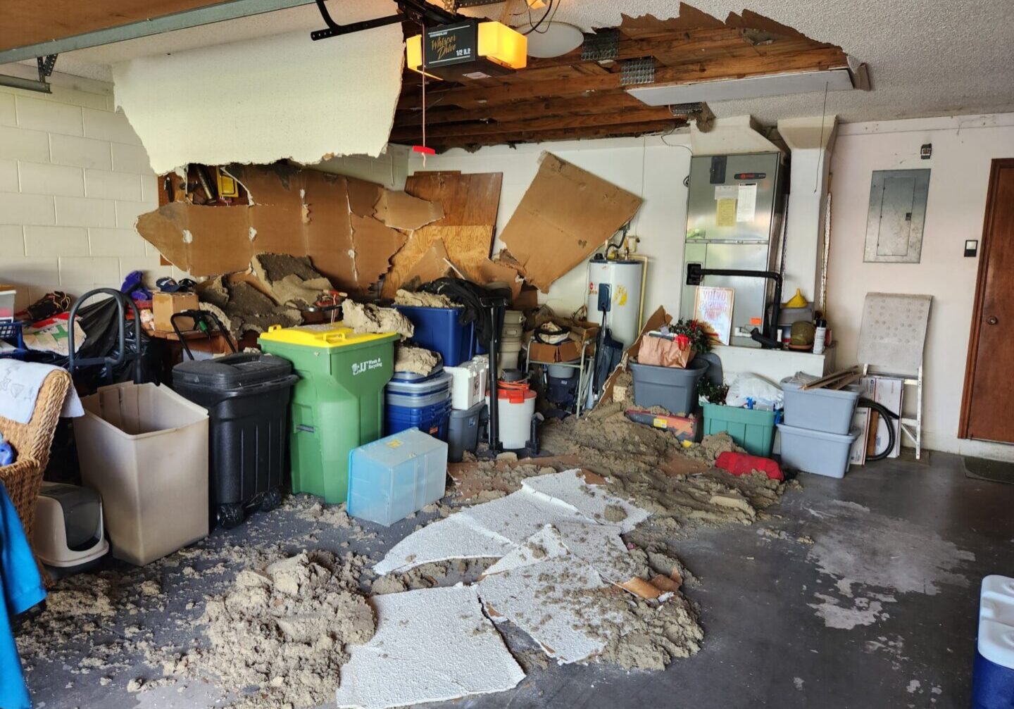A garage with many boxes and debris on the floor.